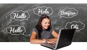 Benefits of Being Bilingual - Woman on Computer With Hello Translated Behind Her