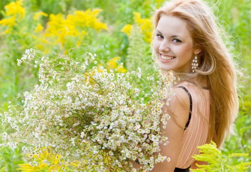Translating Poetry - Blonde Girl Holding Flowers in Field and Smiling 