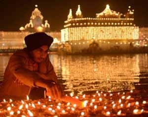 Diwali Celebration - Man Lighting Candles Outside The Golden Temple