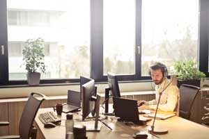 Global Business Language - Man wearing headphones at computer