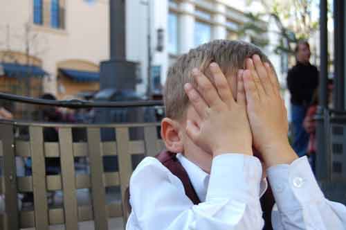 Untranslatable Spanish Words - Young child hiding his face in his hands
