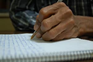 Writing for Translation - Person Writing in Notebook