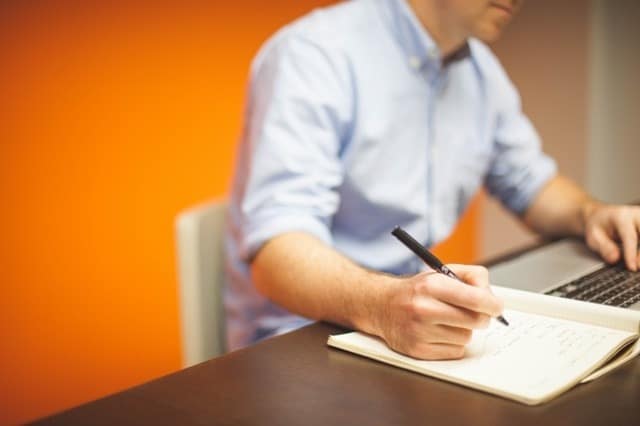 Linguistic Validation - Man Using Computer and Writing