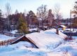 Siberian village at winter covered by snow at evening time