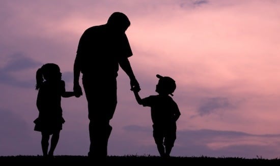 Father holding hands with children