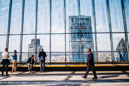 EB 5 Visa Program Ending - Businessman Walking in front of Windows with Skyscraper